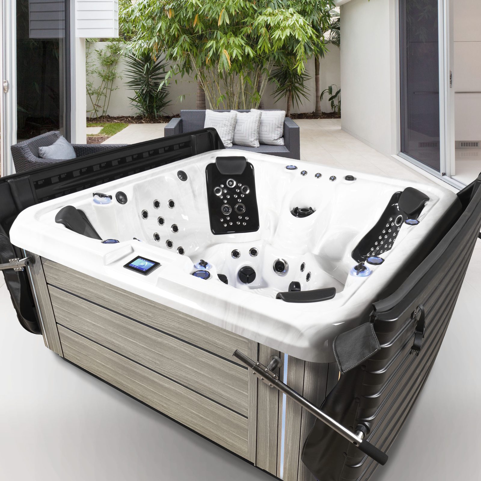 Iconic Series spa on a backyard patio with the DURA-SHIELD HardCover folded open behind it, seats and jets in full view